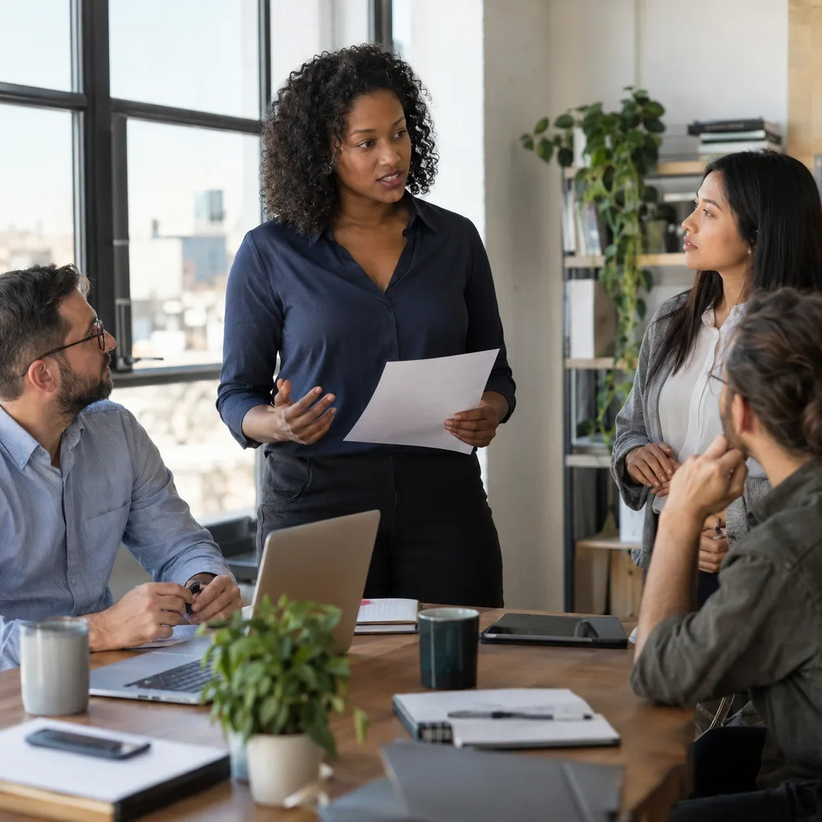 A professional gives a short project update to colleagues at a standing team briefing.